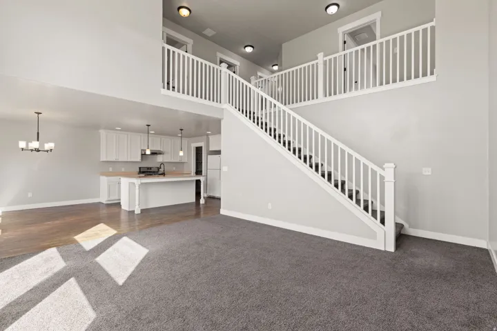 Two-story living area with high ceilings and a white balustrade staircase