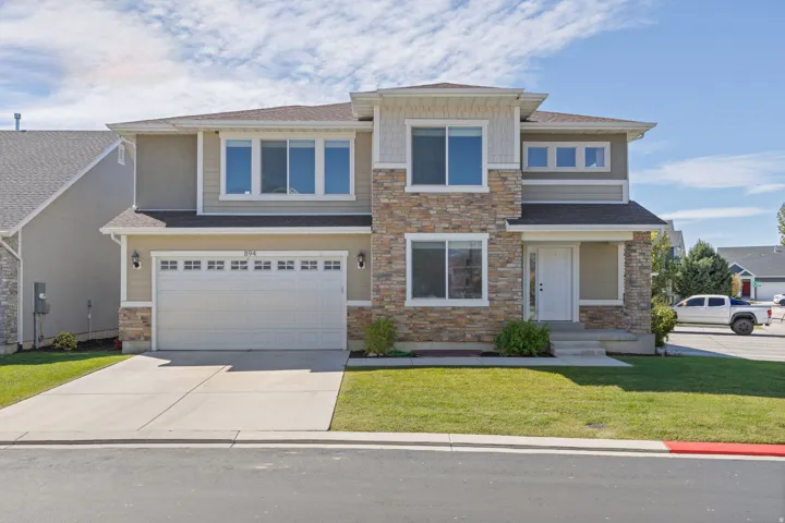 Two-story residence featuring a stone and siding facade, an attached two-car garage, and a concrete driveway