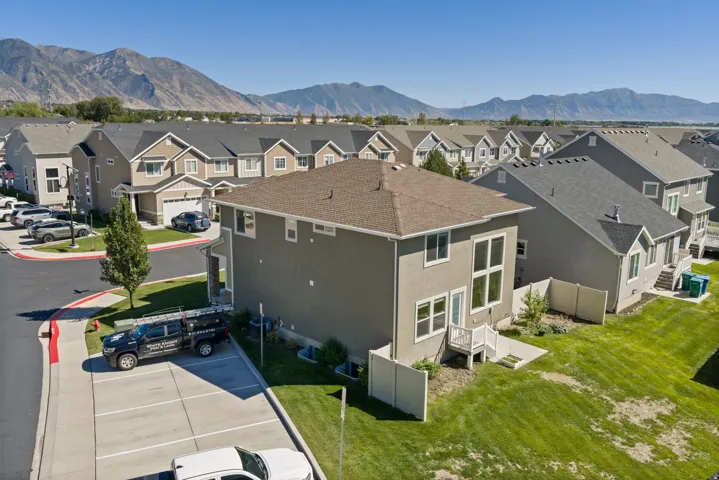 Stucco exterior, multi-pane windows, a private patio, and a sloped lawn