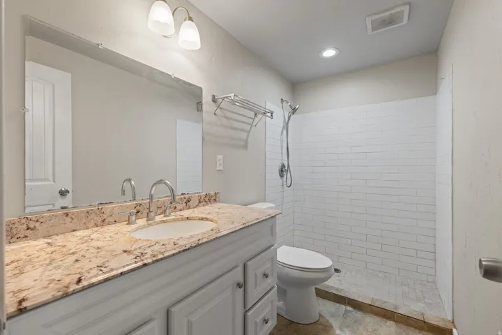Vanity with a polished stone countertop and integrated sink
