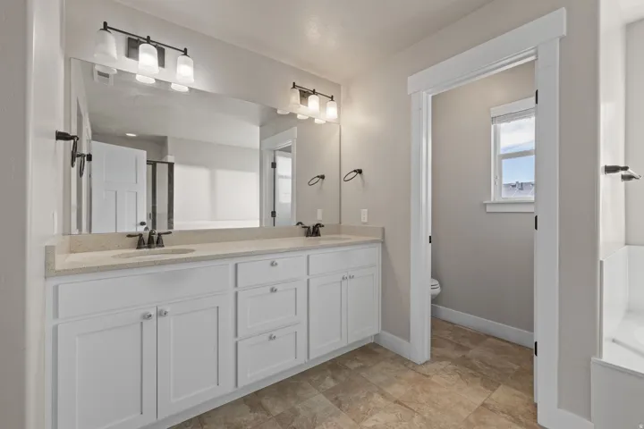 Dual vanity with white cabinetry, light-toned countertop, and undermount sinks