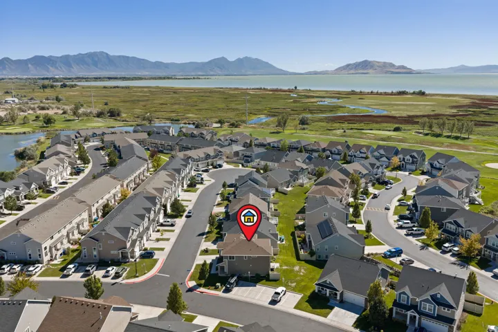 Residential community with a winding street layout, surrounded by natural wetlands and a lake