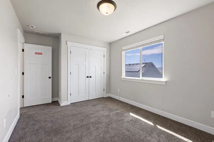 Carpeted room with a double-paned window, white trim, and a semi-flush mount light fixture