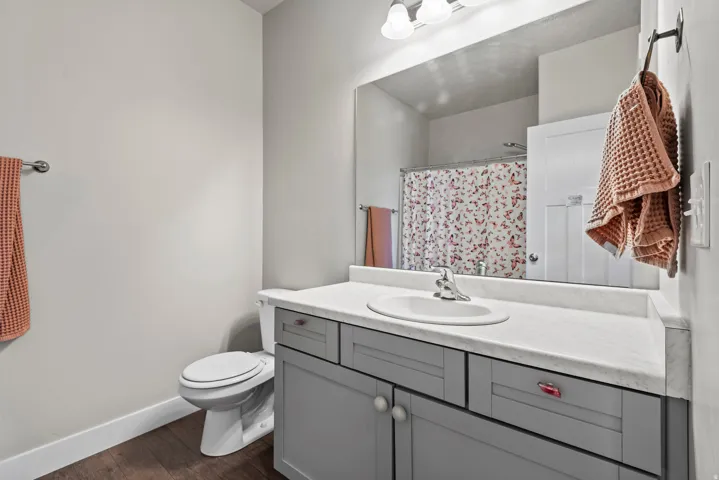 Bathroom featuring a single vanity with a white countertop, an integrated sink, and gray cabinetry