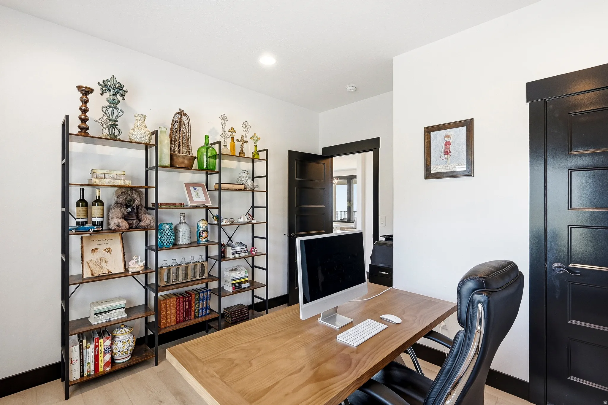 Hardwood-finish flooring, built-in shelving, dark-paneled door, and recessed lighting