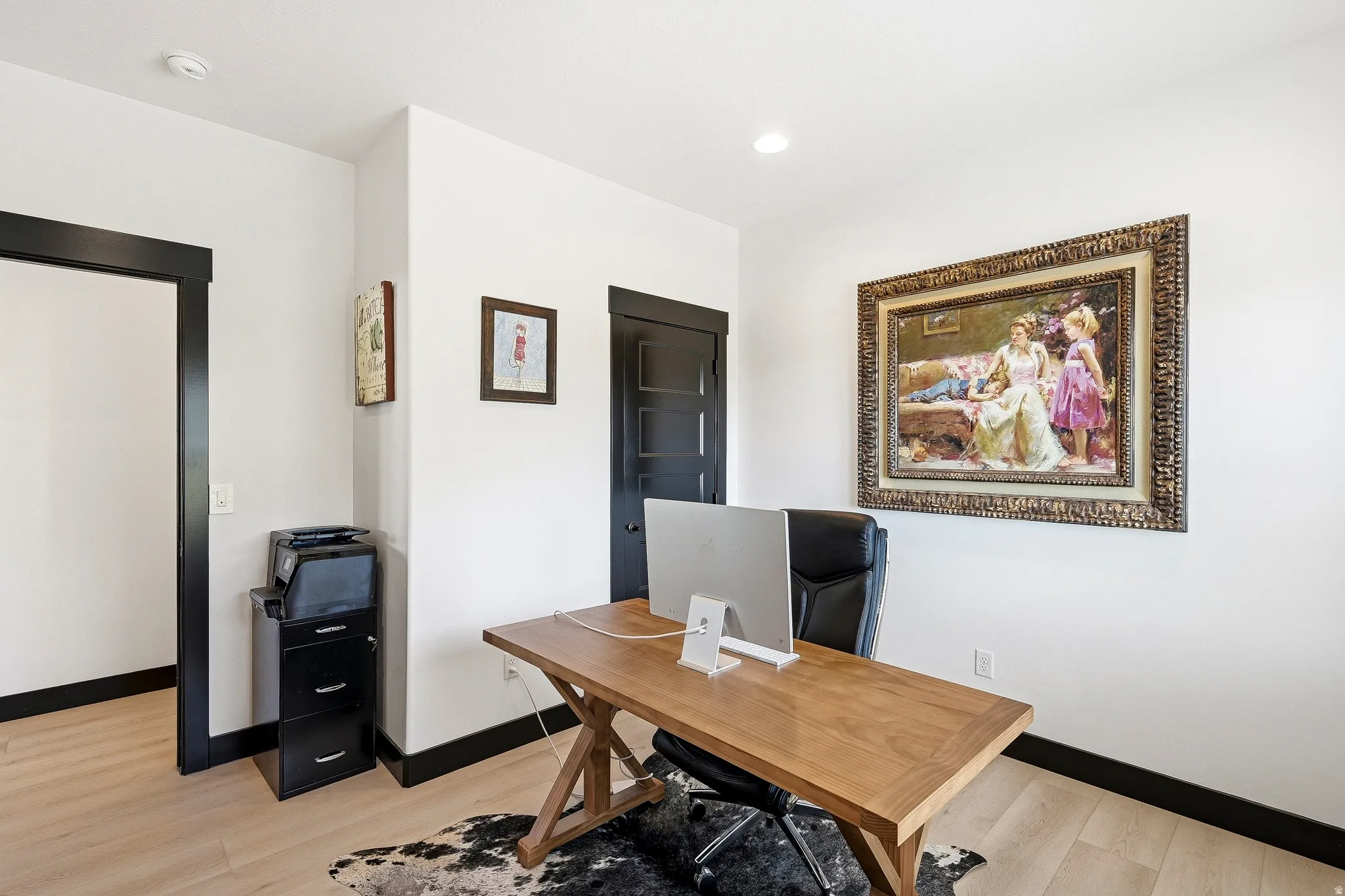 Recessed lighting, light wood-finish flooring, white walls, and dark trim