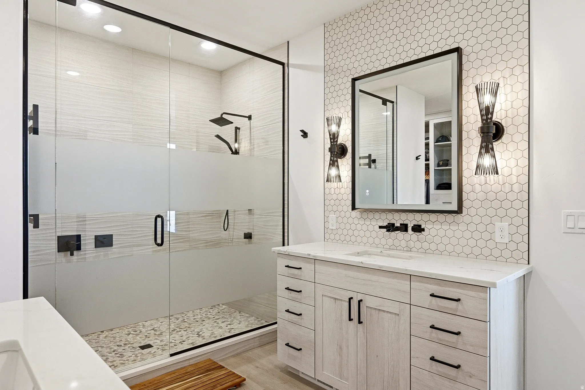 Frameless glass shower enclosure with matte black fixtures