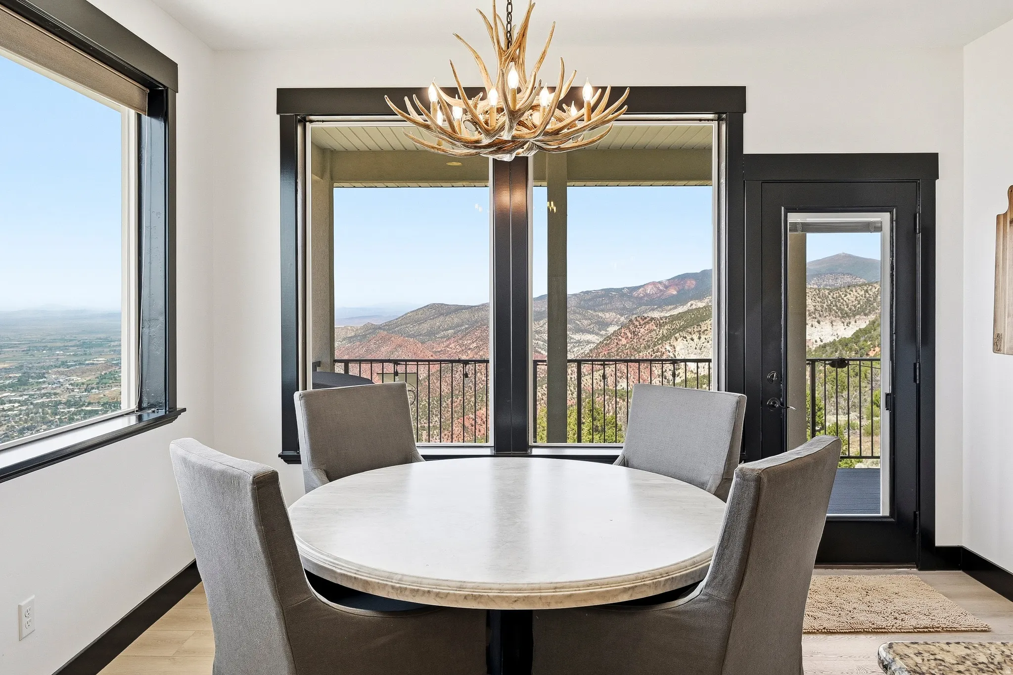 Antler-style chandelier, large picture windows, full-lite exterior door, mountain scenery, and distant city scenery