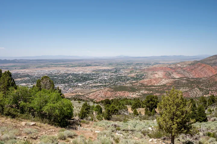 Expansive mountain landscape featuring broad valley and distant city