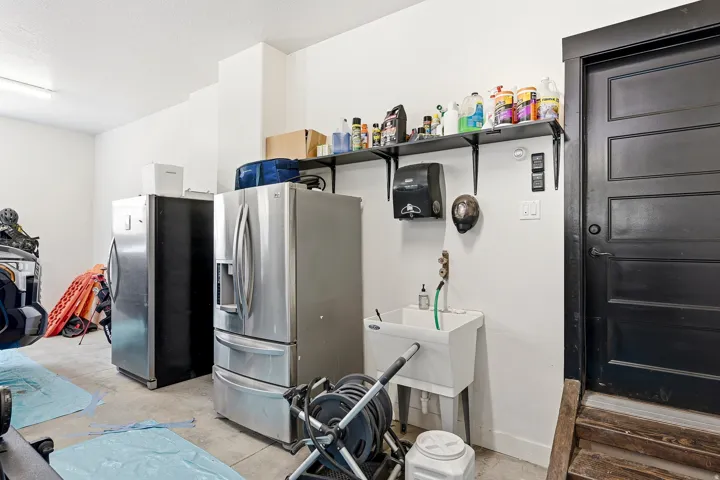 Black paneled door, wall-mounted shelving, and utility sink