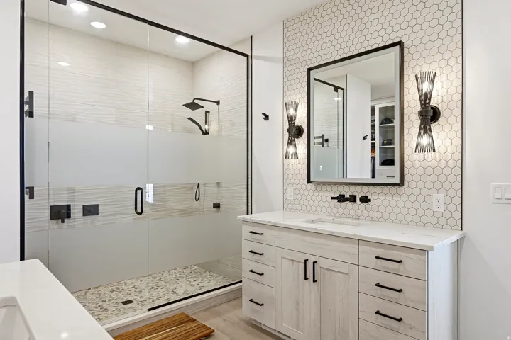 Frameless glass shower enclosure with matte black fixtures