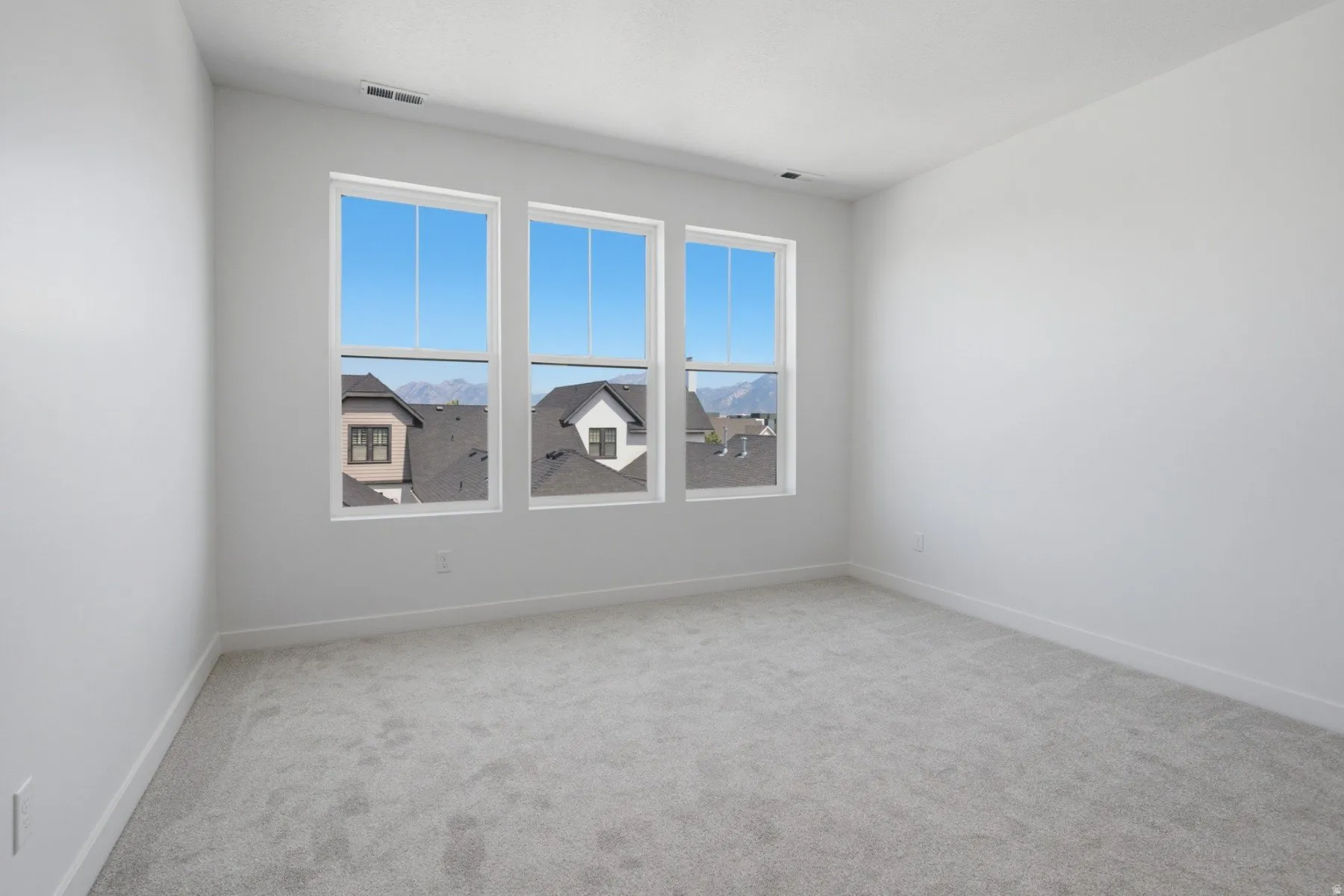 Bright room with light gray carpeting, crisp white walls, and a recessed ceiling