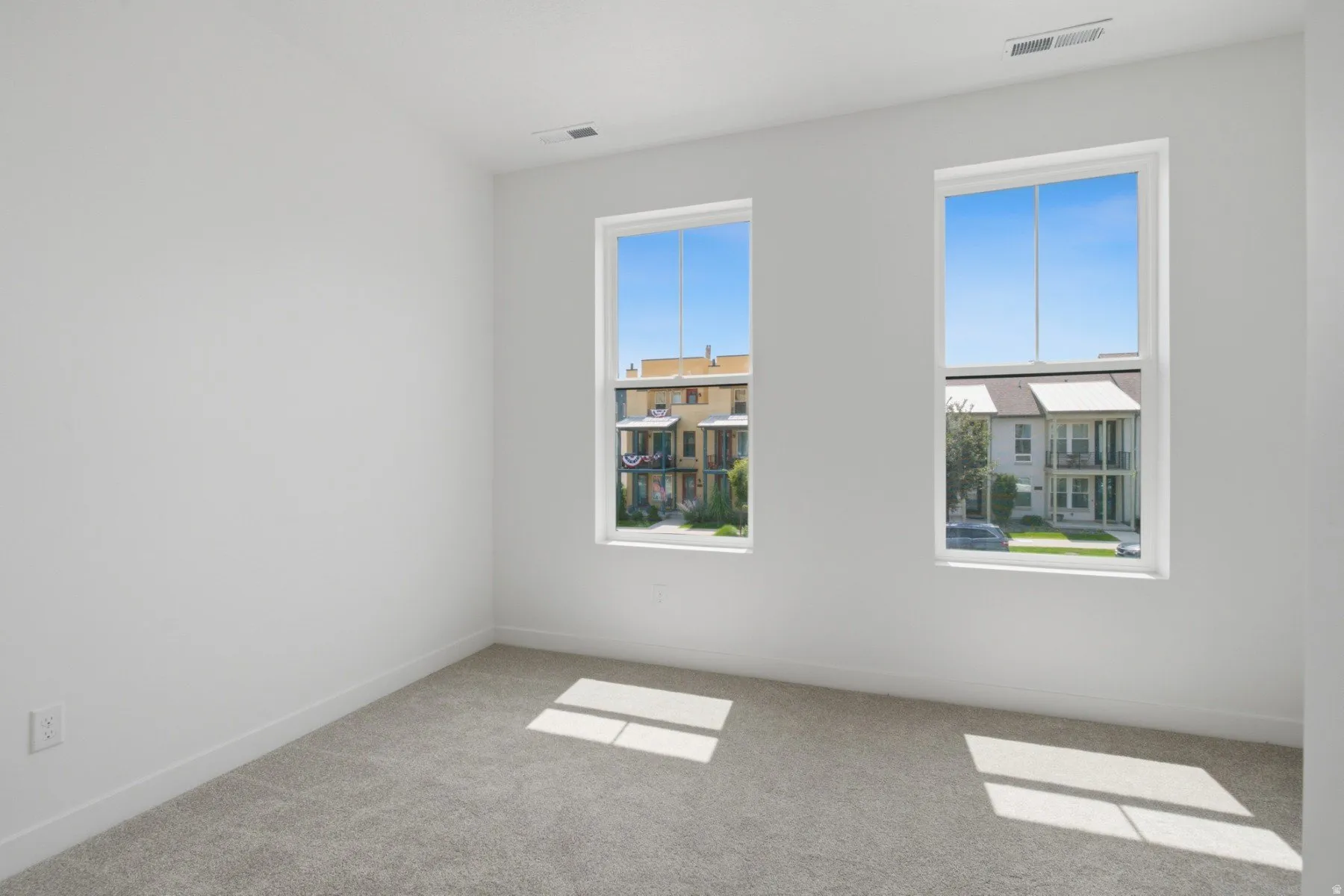 Neutral wall finishes, light gray carpeting, and white trim