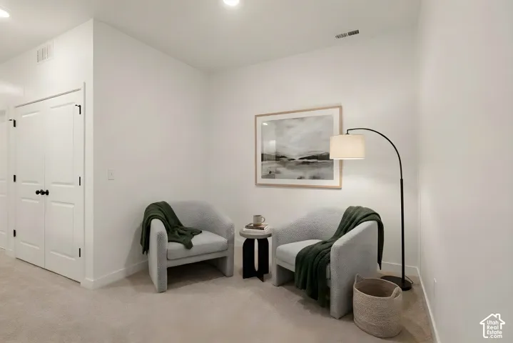 Recessed ceiling lighting illuminates a carpeted interior space with crisp white walls