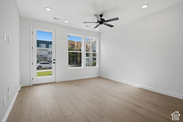 Wood-finish flooring, recessed lighting, and a ceiling fan with integrated light