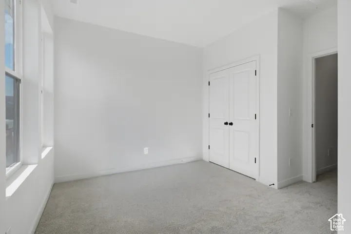 Neutral wall tones, light-toned carpeting, white trim, and a double-panel door