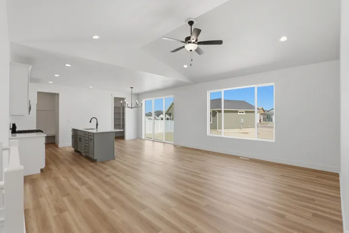 Spacious open-concept layout with vaulted ceiling and wood-finish flooring