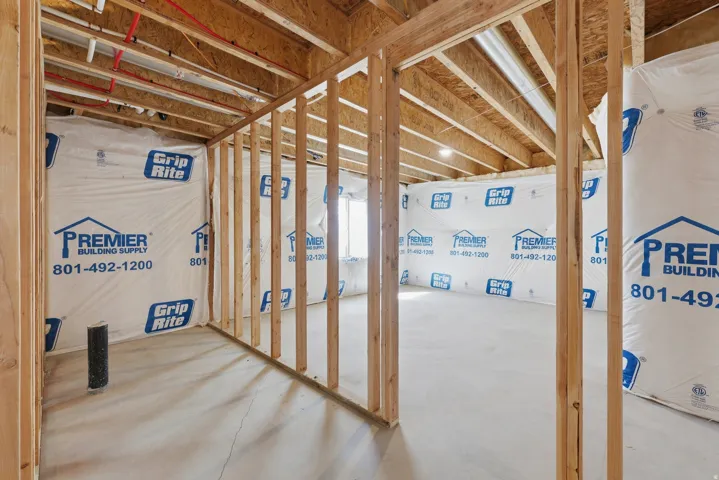 Unfinished basement with exposed wood framing, concrete flooring, and visible overhead joists