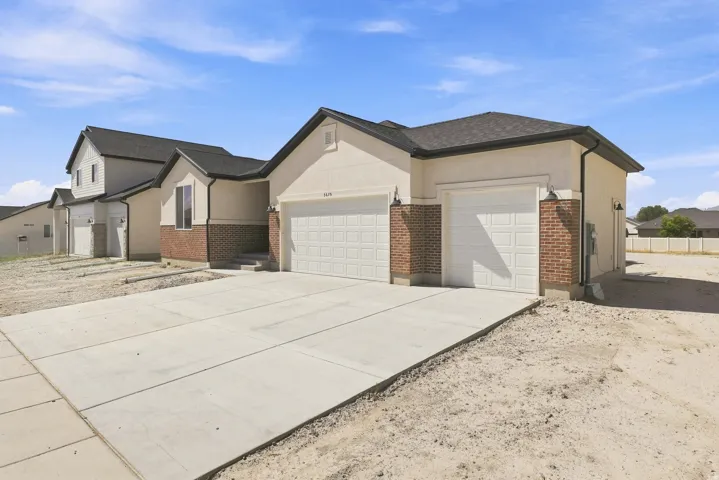 Stucco and brick exterior with a two-car garage