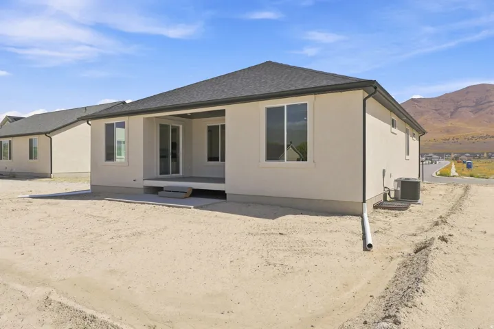 Rear exterior with a covered patio, sliding glass doors, and a concrete patio