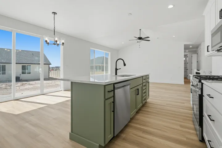 Modern kitchen island featuring a sink with a matte black faucet, integrated dishwasher, and green cabinetry