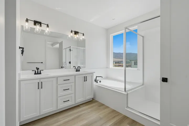 Dual vanity with white cabinetry, quartz-finish countertop, and black hardware