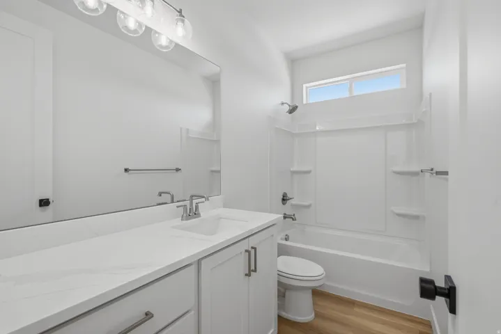 White vanity with a light-toned countertop and an integrated sink