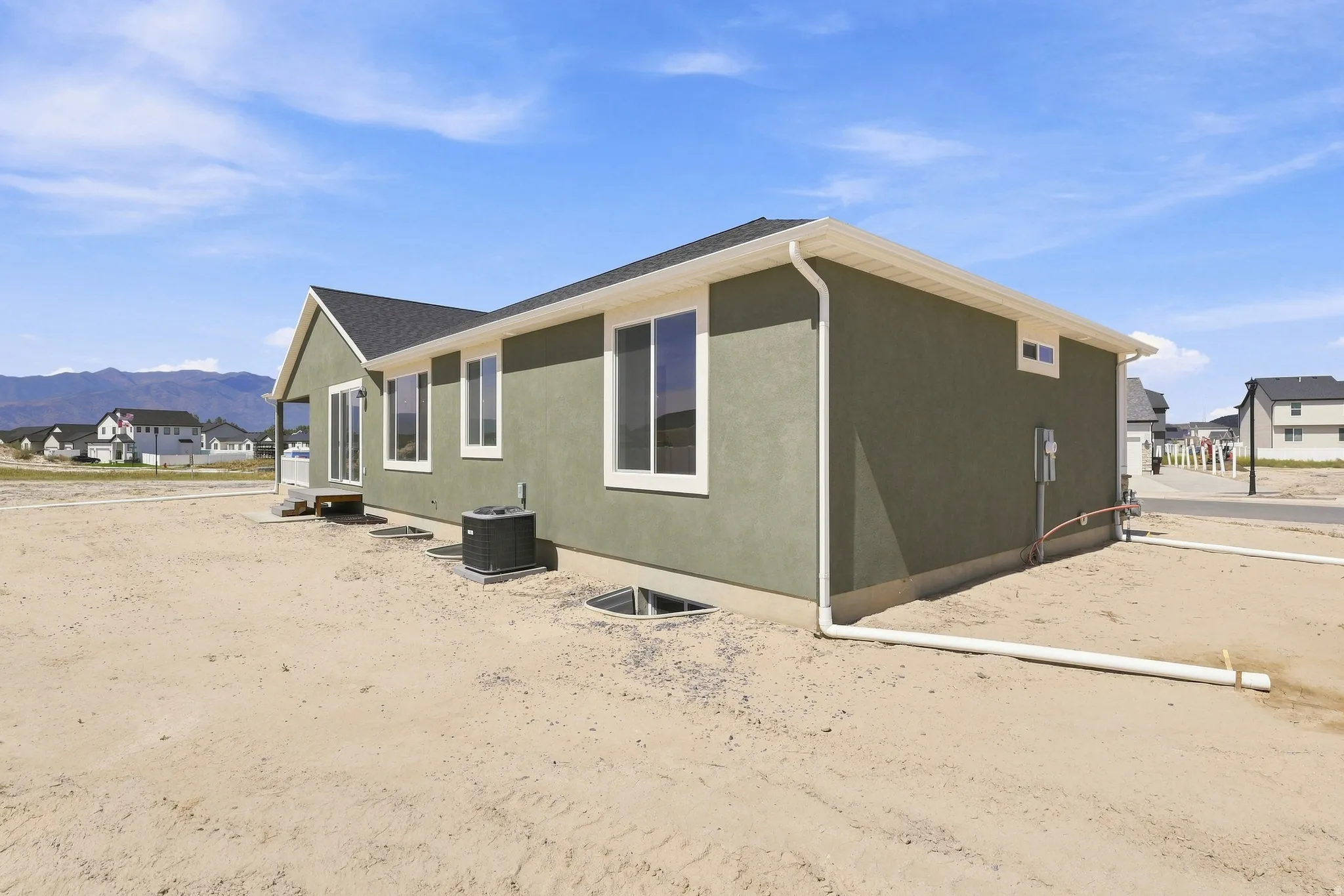 Stucco exterior featuring multiple windows and a sliding glass door