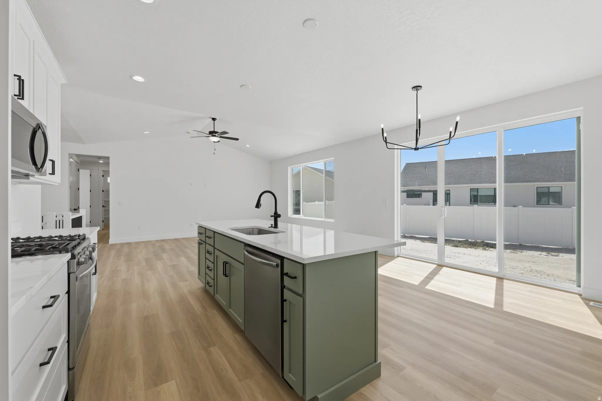 Kitchen island with a white countertop and integrated sink, stainless steel dishwasher, and matte black faucet