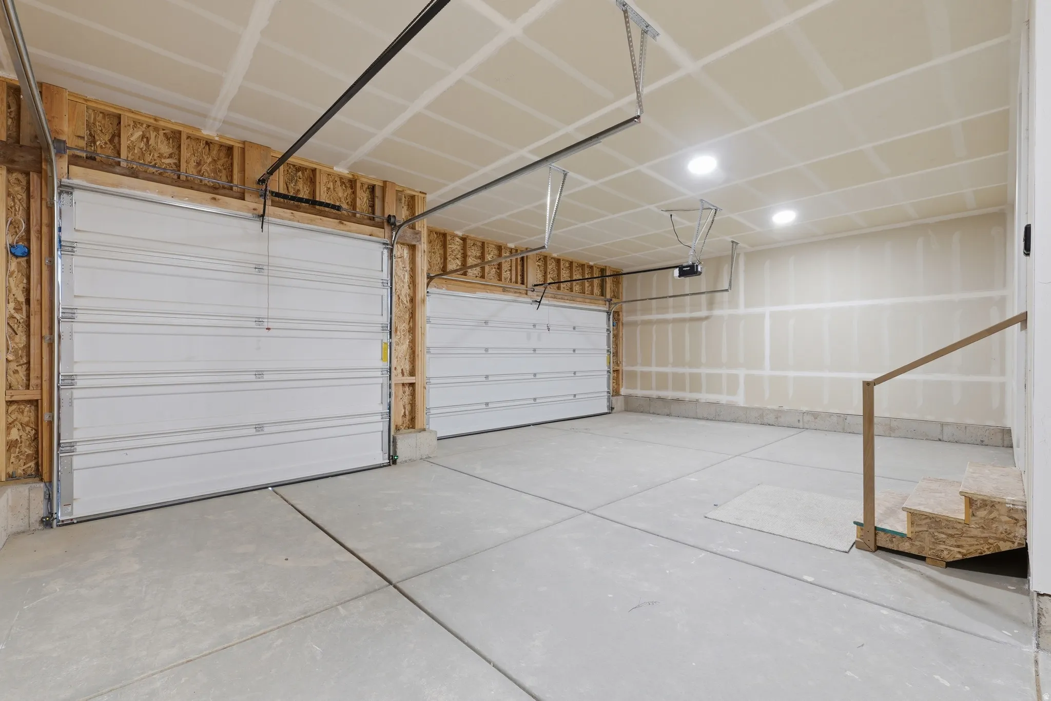 Two white sectional garage doors