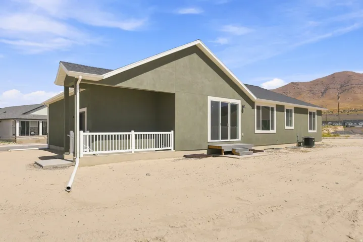 Stucco exterior with a covered patio and white railing