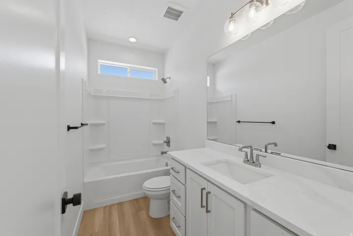 Bathroom featuring a single vanity with a white countertop, chrome faucet, and integrated sink