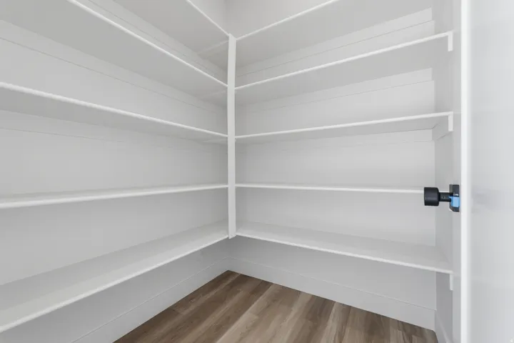 Corner pantry with white shelving, offering ample storage