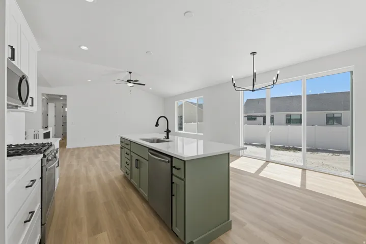 Kitchen island with a white countertop and integrated sink, stainless steel dishwasher, and matte black faucet