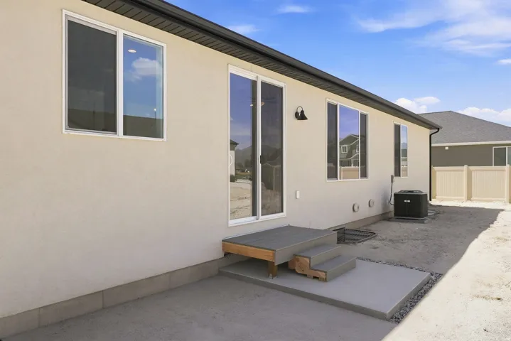 Cream stucco exterior with white-framed windows and a sliding glass door