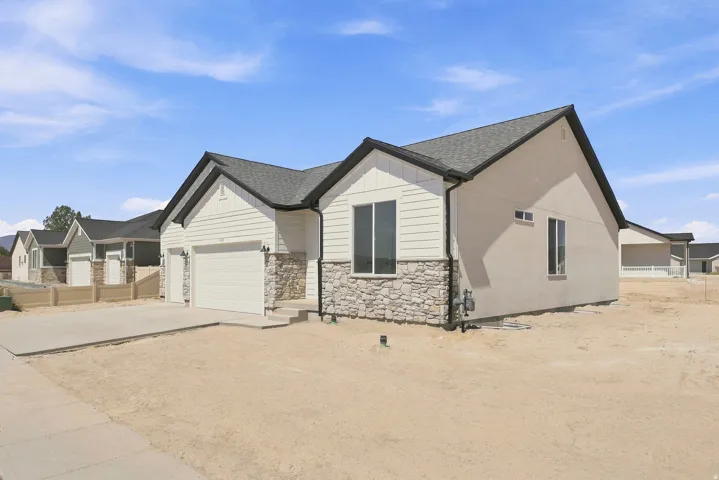 Exterior facade with horizontal siding, stone veneer accents, multiple large windows, and an attached two-car garage