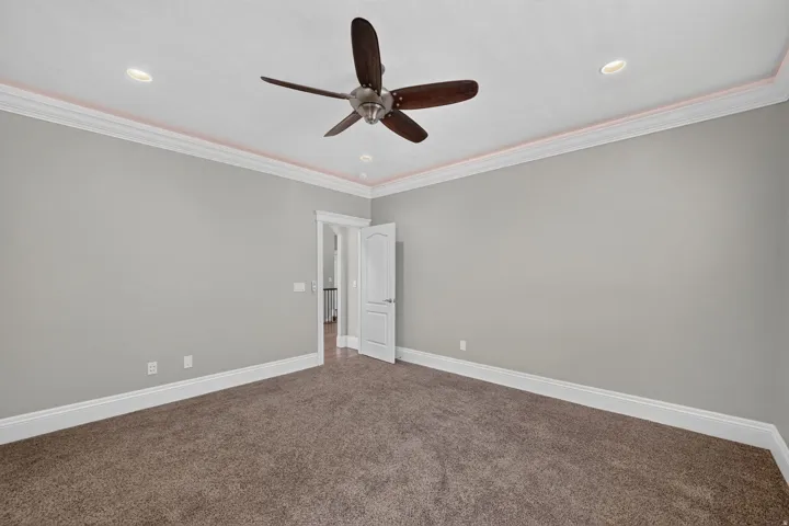 Recessed lighting, crown molding, and a ceiling fan with integrated lighting