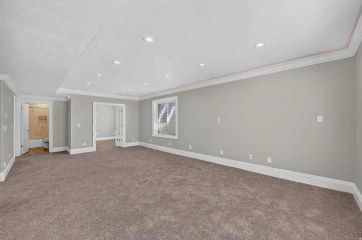 Recessed lighting, crown molding, light gray wall paint, white trim, and brown carpet flooring
