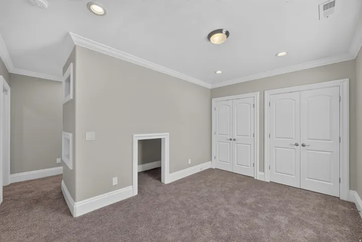 Recessed lighting, crown molding, two sets of double-door closets, and an arched entry