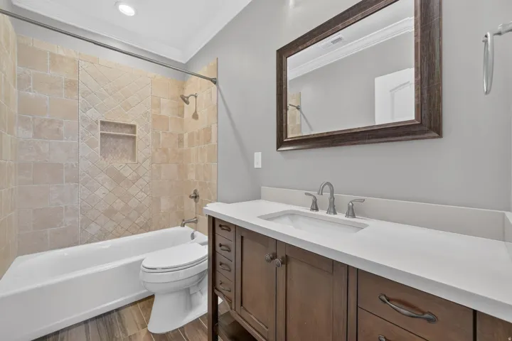 Wood-finish flooring with a white bathtub and toilet