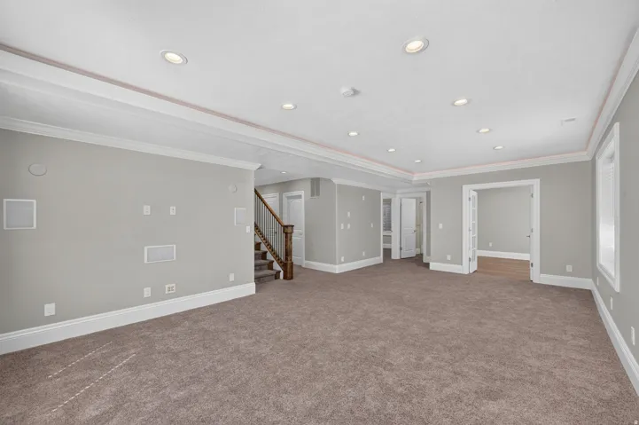 Spacious interior with recessed lighting, crown molding, and carpet flooring