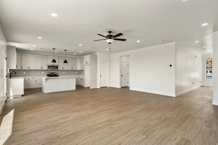 Open-concept living space featuring wood-finish flooring, recessed lighting, and a modern ceiling fan