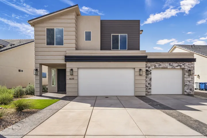 Contemporary exterior with a two-car garage, stacked stone accents, horizontal siding, and modern outdoor lighting fixtures