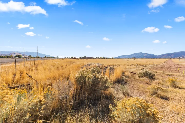 Expansive open lot featuring natural vegetation and distant mountain ranges