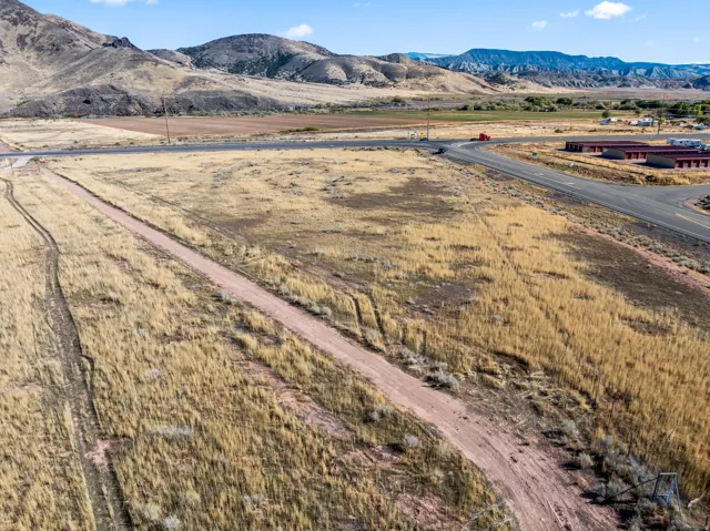 Expansive open land featuring natural vegetation and a dirt track