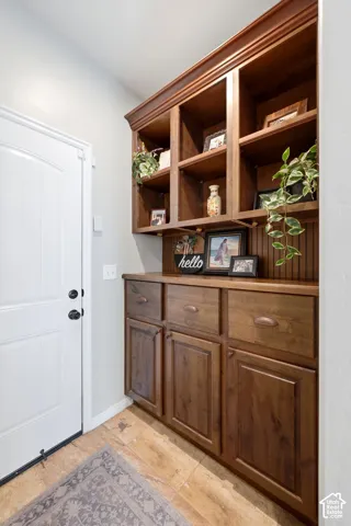 Built-in wood cabinetry with drawers and open shelving, beadboard backing, and a wood countertop
