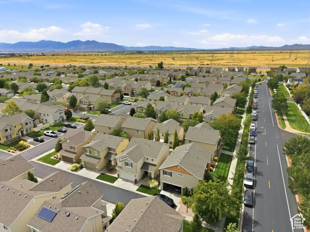 Residential neighborhood featuring multiple two-story homes, well-maintained streets, green landscaping, and distant mountain scenery