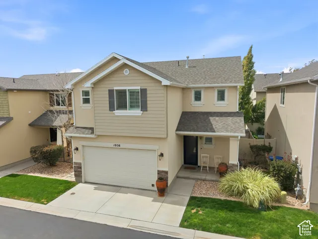 Two-story residence featuring a two-tone exterior, attached garage, and a covered entry