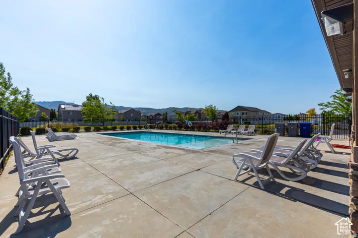 Outdoor swimming pool with a surrounding concrete deck and black metal fencing
