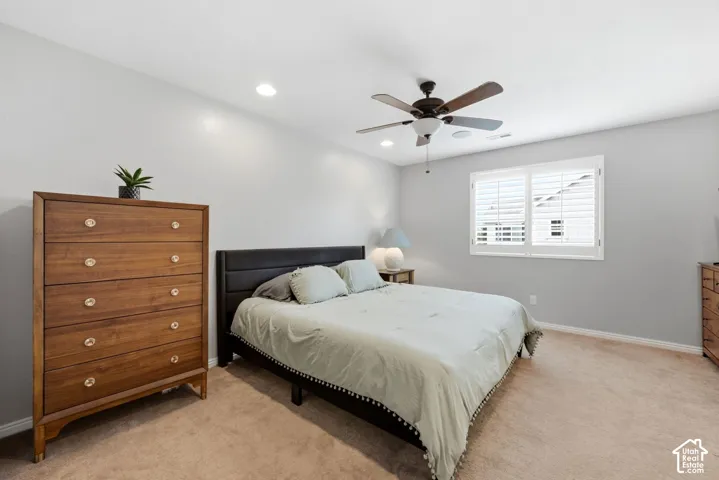 Recessed lighting, ceiling fan, window with plantation shutters, light-colored walls, and carpeted flooring